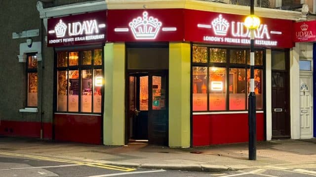 Street‑level view of Udaya Kerala Restaurant on Katherine Road in East Ham, London, with its white frontage, large bay windows and the green‑and‑red sign that reads “UDAYA – Indian & Kerala Cuisine