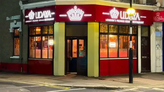 Street‑level view of Udaya Kerala Restaurant on Katherine Road in East Ham, London, with its white frontage, large bay windows and the green‑and‑red sign that reads “UDAYA – Indian & Kerala Cuisine